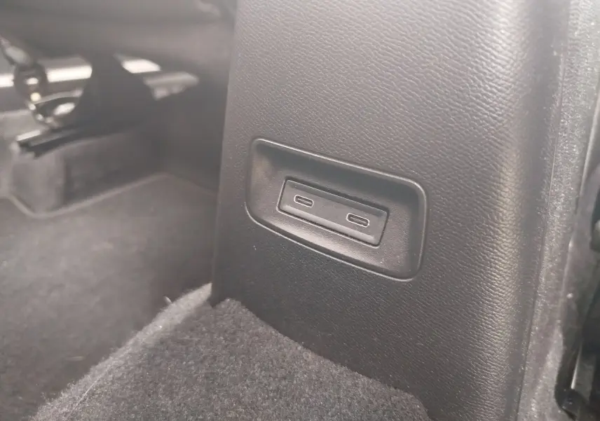 Gros plan sur les ports USB-C situés à l'arrière de la console centrale d'une Citroën C3 2025 gris foncé.