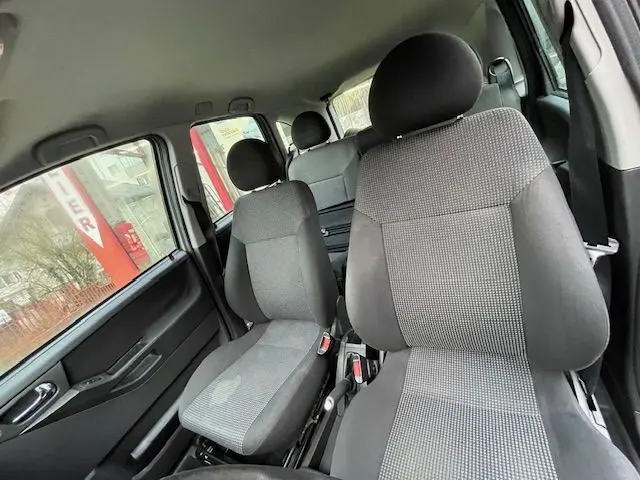 Intérieur de l'Opel Meriva 2010 montrant les sièges avant en tissu gris avec appuie-têtes et ceinture de sécurité côté gauche.