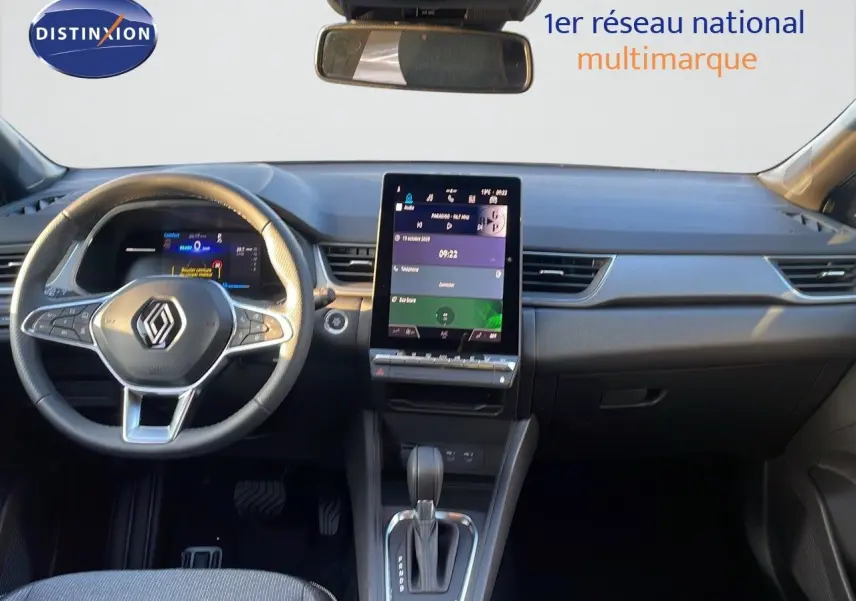 Vue intérieure du tableau de bord du Renault Captur E-Tech gris cassiopée, avec écran tactile vertical et volant multifonction.