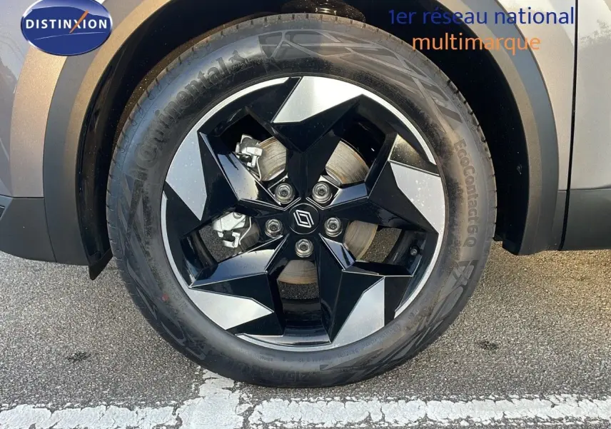 Gros plan sur la roue avant droite du Renault Captur gris Cassiopée Métal avec jante noire et argentée au design géométrique.