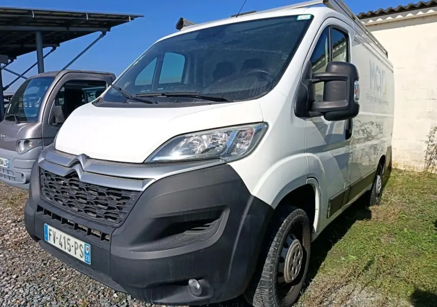 Vue 3/4 avant droit d'un utilitaire Citroën Jumper blanc 2020 avec galerie de toit et pare-chocs noir.