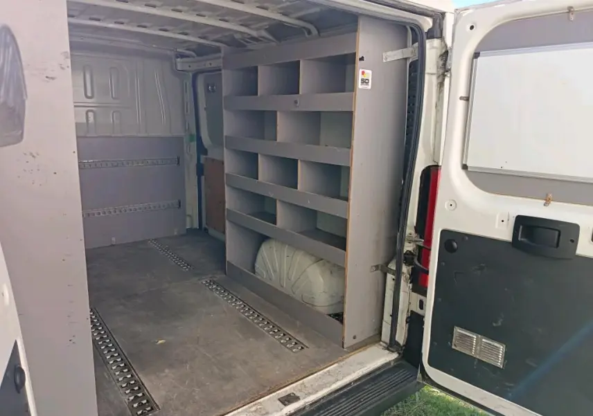 Vue intérieure arrière du Citroën Jumper blanc 2020 avec étagères de rangement et porte ouverte côté droit.