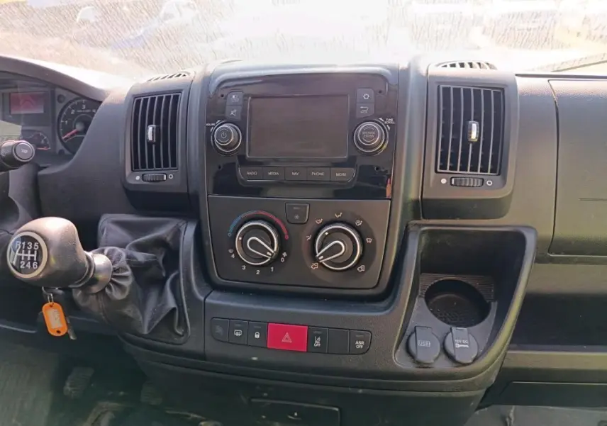 Tableau de bord du Citroën Jumper blanc 2020, vue frontale centrée sur la console avec commandes manuelles et écran éteint.