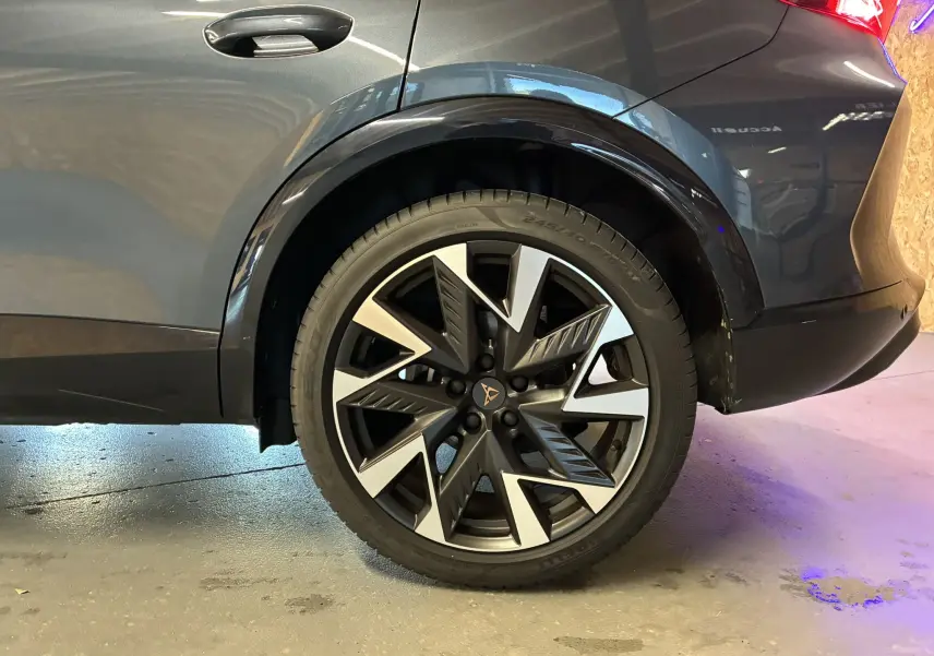 Gros plan sur la roue arrière droite du CUPRA Formentor gris foncé 2024, mettant en valeur la jante bi-ton au design dynamique.