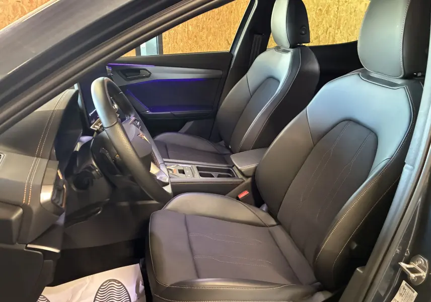 Intérieur noir du CUPRA Formentor 1.5 hybride 2024 vu côté conducteur, sièges cuir et ambiance lumineuse violette.