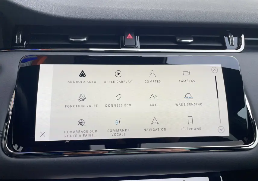 Gros plan sur les commandes noires du volant du Range Rover Evoque 200D SE R-Dynamic en Eiger Grey, finition intérieure cuir noir.