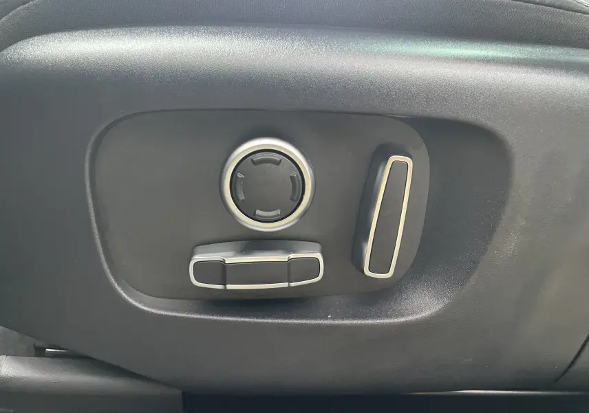 Gros plan sur l’inscription R-Dynamic en rouge et chrome sur la porte côté droit d’un Range Rover Evoque gris Eiger.