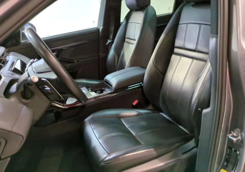 Vue arrière d'un Range Rover Evoque 200D SE R-Dynamic gris Eiger avec feux LED allumés, stationné devant un showroom.