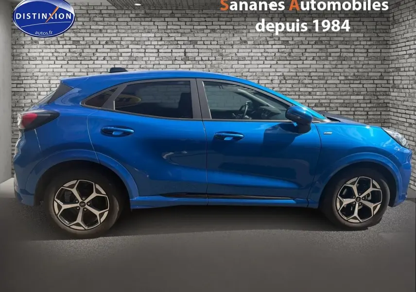 Vue de profil côté gauche d'un Ford Puma bleu métallisé avec jantes alliage 17 pouces et vitres arrière surteintées.