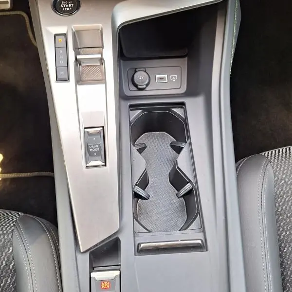 Vue plongeante sur la console centrale de la Peugeot 308 Hybrid 145 e-DCS6 GT 2025, avec bouton start, levier de vitesses et prises USB.