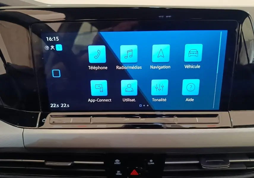 Écran tactile central bleu affichant les fonctions multimédias dans l’habitacle d’une Volkswagen Golf noire 2023.
