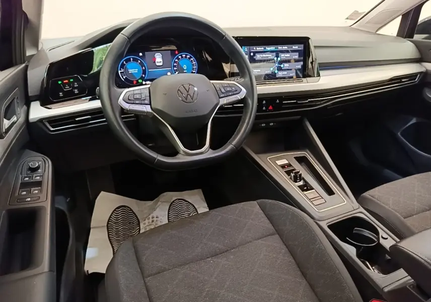 Intérieur de la Volkswagen Golf 2.0 TDI 2023, vue avant centrée sur le volant cuir et l’écran tactile noir.