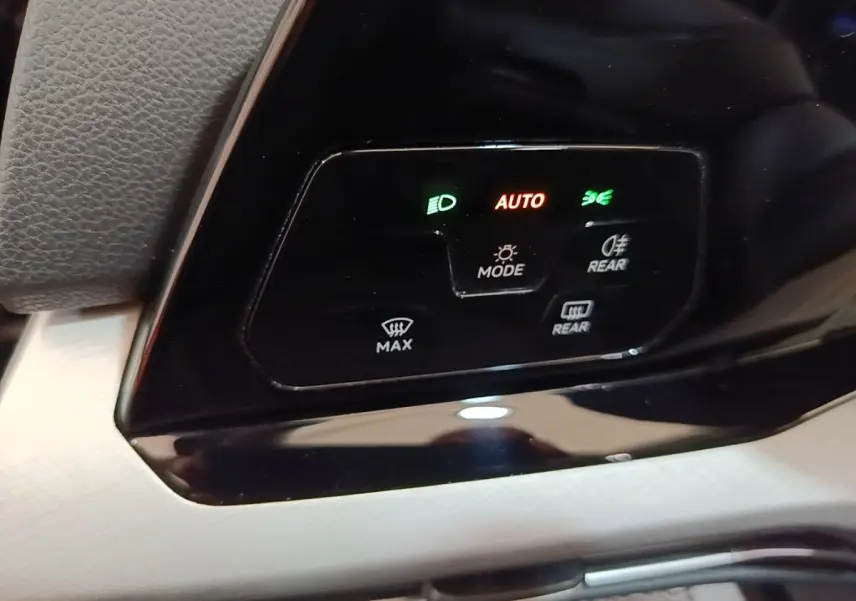 Détail du panneau de commande des feux et désembuage dans une Volkswagen Golf noire 2023, avec affichage lumineux.