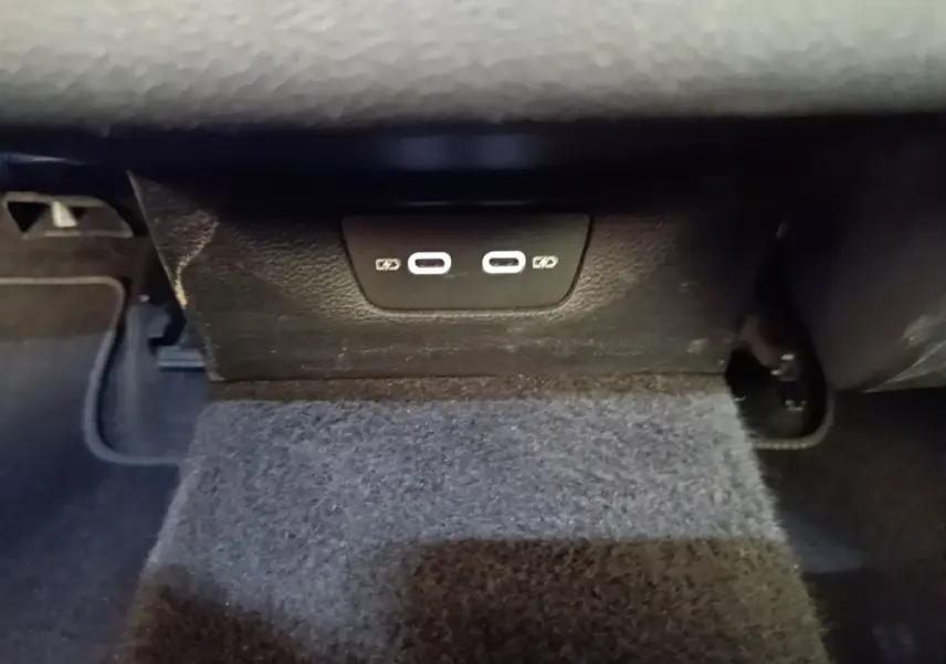 Vue rapprochée des ports USB-C de recharge situés sous le tableau de bord d'une Volkswagen Golf noire 2023.
