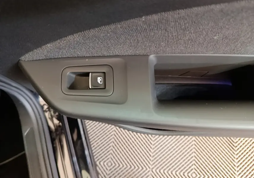 Détail de la commande de verrouillage de porte sur la portière avant gauche d’une Volkswagen Golf noire 2023.
