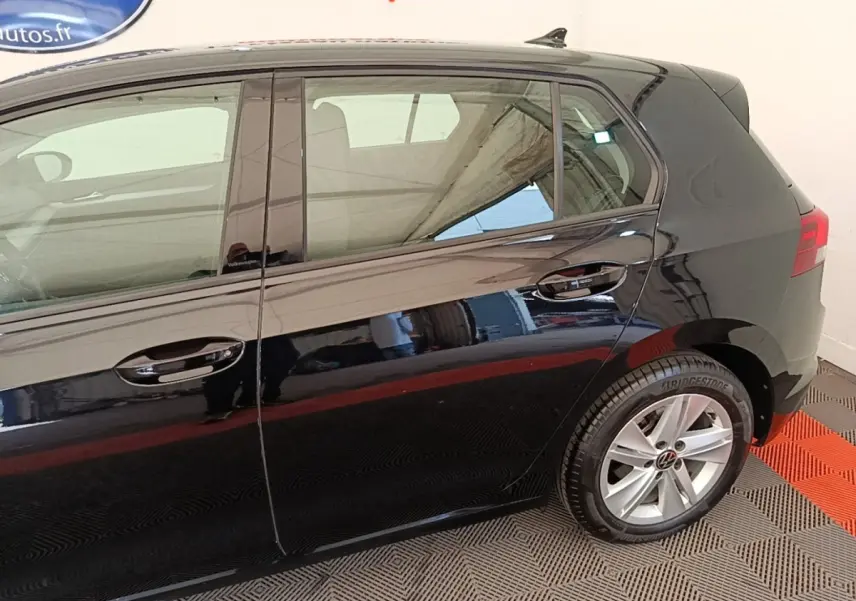 Vue latérale droite d'une Volkswagen Golf noire 2023, mettant en valeur les jantes alliage et les vitres teintées.
