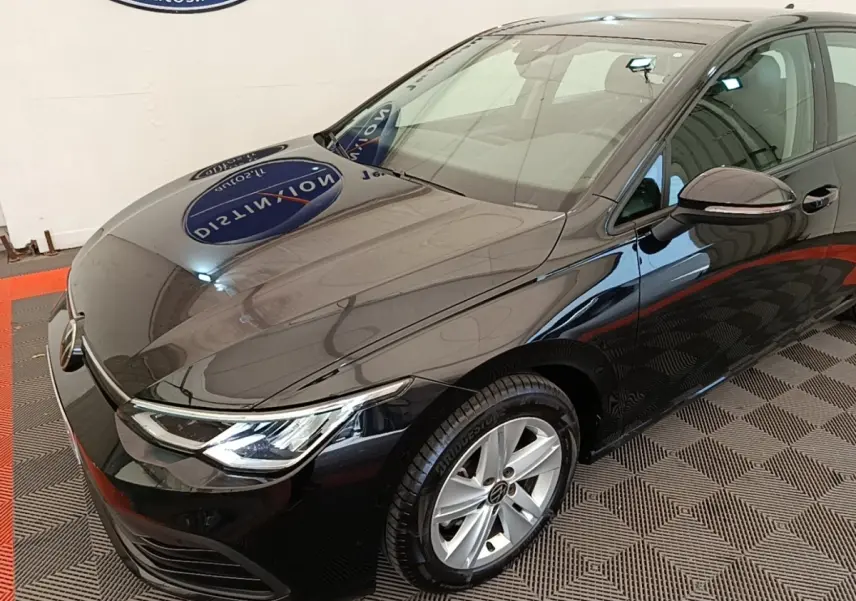 Volkswagen Golf noire vue 3/4 avant droit, avec phares LED et jantes alliage argentées visibles.