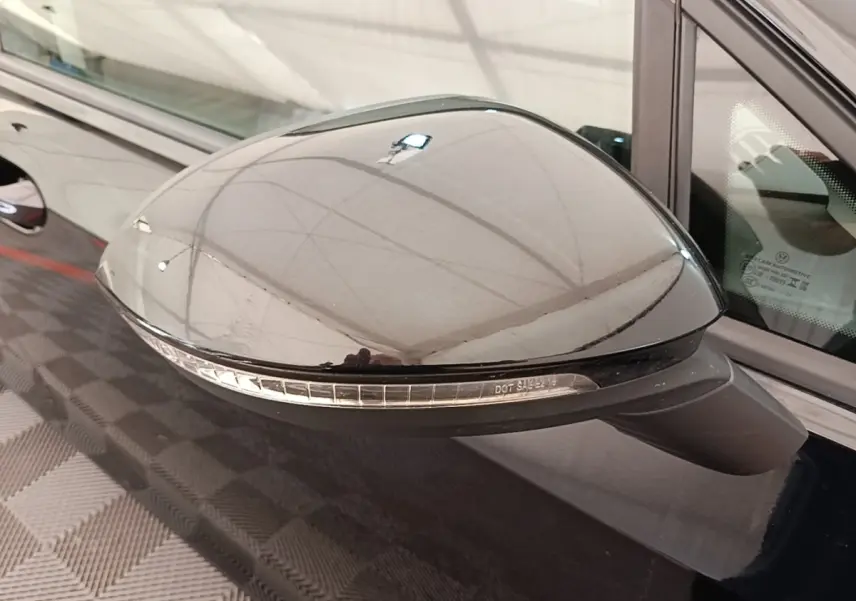 Rétroviseur côté gauche noir brillant avec clignotant intégré sur Volkswagen Golf 2023 vue rapprochée.
