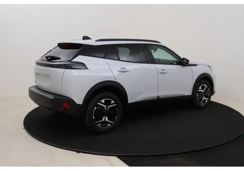 Peugeot 2008 blanc Okenite en vue 3/4 arrière droit, avec barres de toit noires et jantes distinctives.
