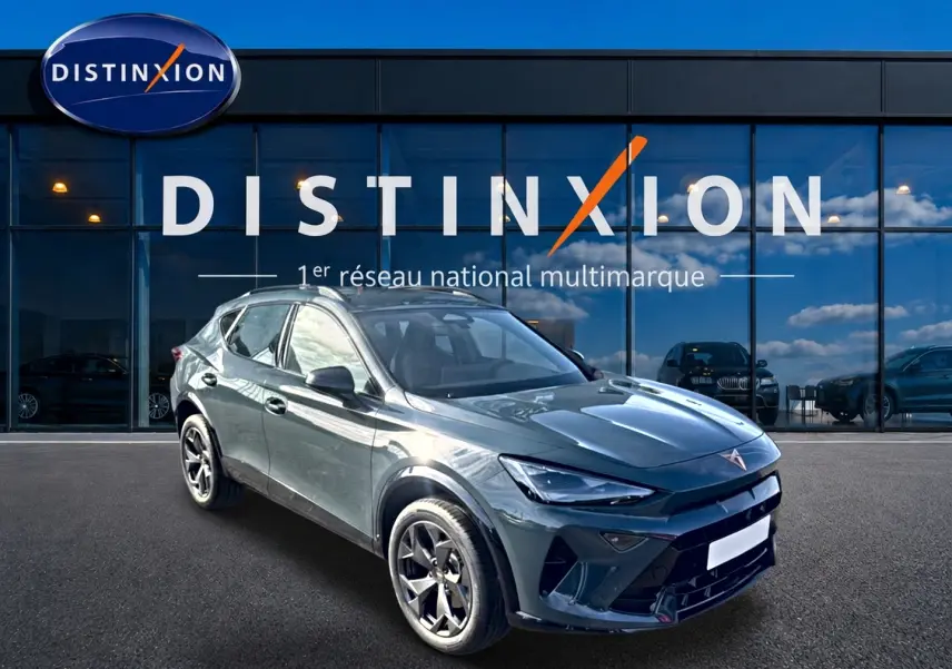 Vue 3/4 avant d'un CUPRA Formentor bleu fjord 2026 avec jantes 18 pouces, devant une vitrine Distinxion.