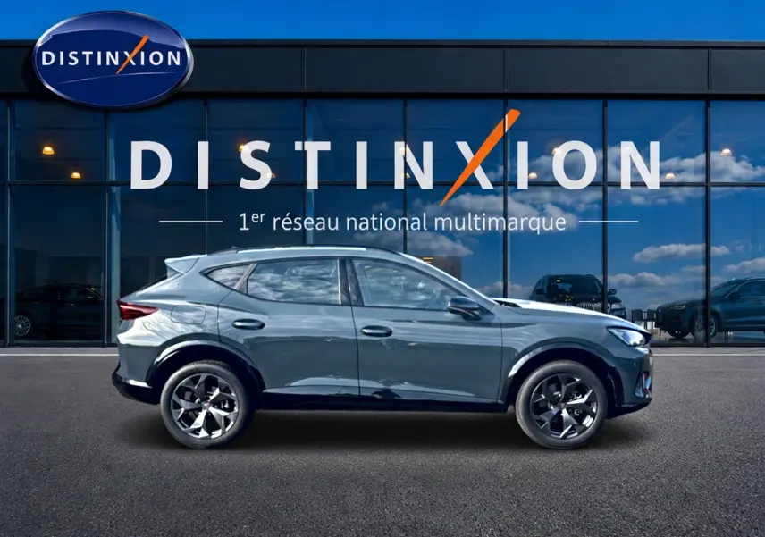 Vue latérale droite d'un CUPRA Formentor bleu fjord 2026 avec jantes 18 pouces devant une vitrine Distinxion.