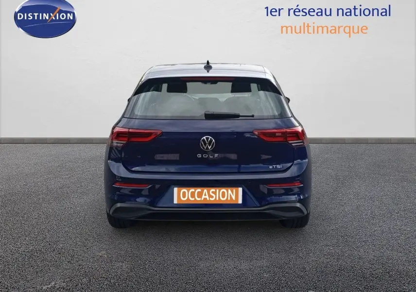 Vue arrière d'une Volkswagen Golf VIII bleu Atlantique métal avec logo et badge eTSI visibles sur fond neutre.