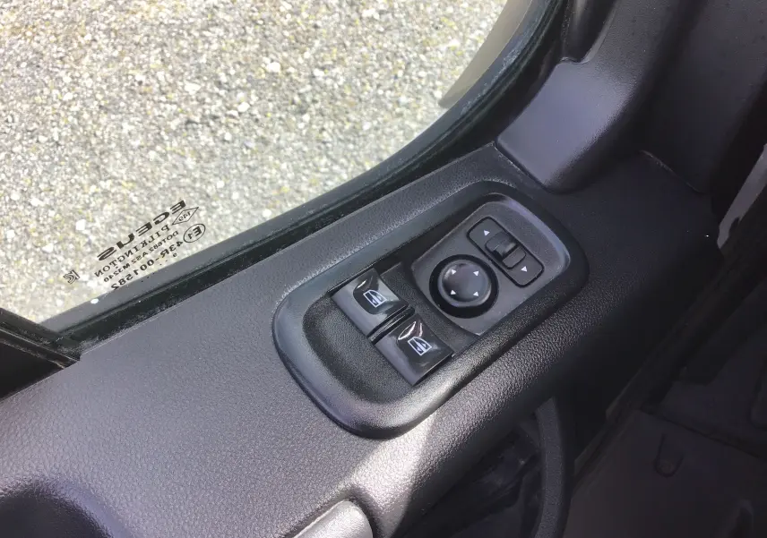 Gros plan sur les commandes électriques des vitres et rétroviseurs côté gauche d’un Renault Master Châssis Cabine blanc.