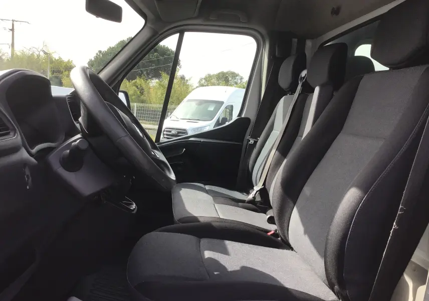 Vue intérieure côté conducteur du Renault Master Châssis Cabine blanc, montrant les sièges avant et le volant.