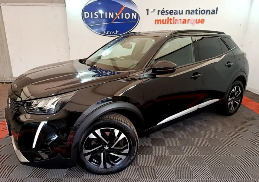 Peugeot 2008 noir vue 3/4 avant droit en intérieur, avec jantes alliage et feux LED distinctifs.