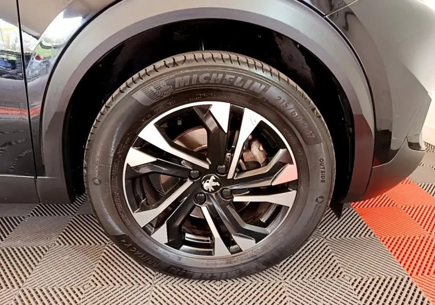 Gros plan sur la roue arrière droite noire avec jante alliage bicolore du Peugeot 2008 BlueHDi 130 de 2021.