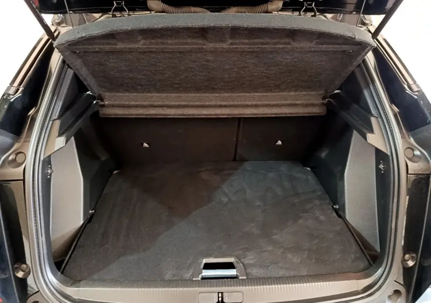 Coffre ouvert vu de l'arrière d'un Peugeot 2008 noir, montrant l'espace de chargement et la tablette de séparation.