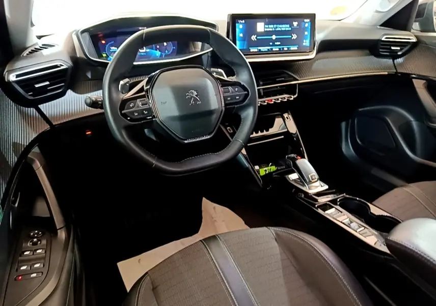 Vue intérieure de la Peugeot 2008 noire, tableau de bord moderne avec écran tactile 10 pouces et volant cuir multifonctions.