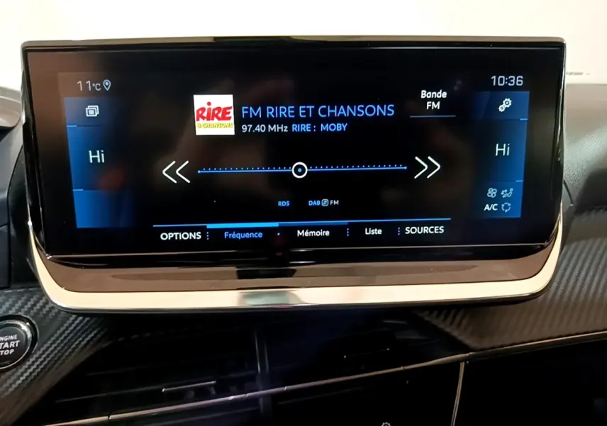 Écran tactile central affichant la radio FM dans l'habitacle noir du Peugeot 2008 BlueHDi 130, vue de face.