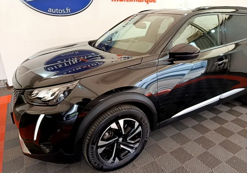 Peugeot 2008 noir en 3/4 avant droit, avec jantes alliage noires et feux LED distinctifs allumés.