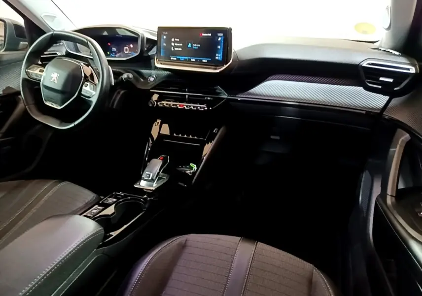 Vue intérieure avant du Peugeot 2008 noir 2021, avec tableau de bord digital et écran tactile central lumineux.