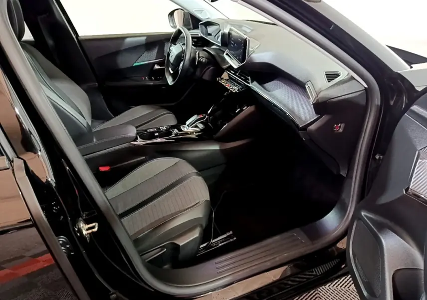 Intérieur avant droit du Peugeot 2008 noir, mettant en valeur sièges, tableau de bord et écran tactile central.