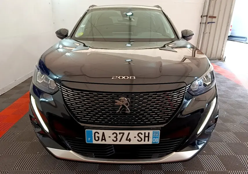 Vue avant d'un Peugeot 2008 noir avec calandre distinctive et feux LED en forme de griffes allumés.