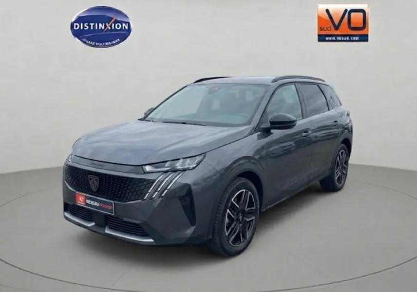 Peugeot 5008 Hybrid gris en vue 3/4 avant droit, avec calandre noire et feux LED distinctifs.