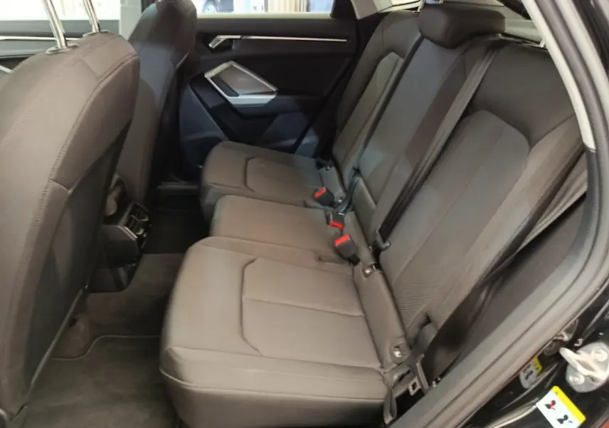 Vue intérieure côté droit sur la banquette arrière noire de l'Audi Q3 Sportback 35 TDI 150 Business Line 2023.