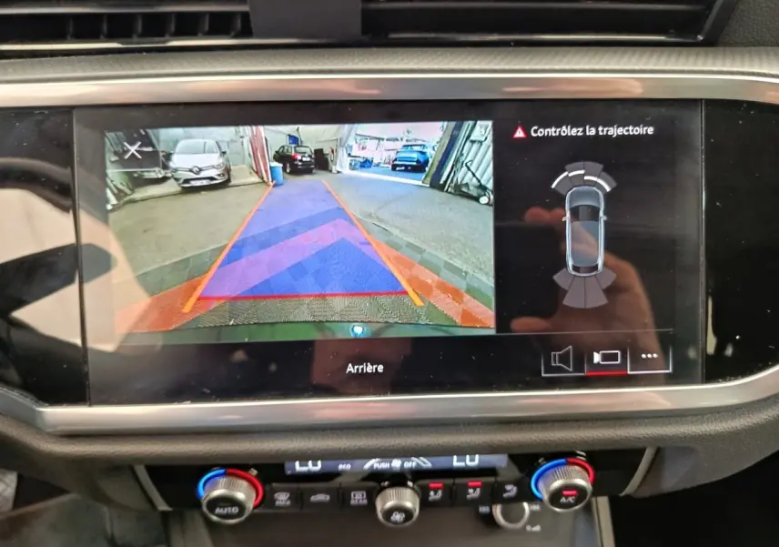 Écran tactile central montrant la caméra de recul et l'aide au stationnement du tableau de bord d'Audi Q3 Sportback noir.