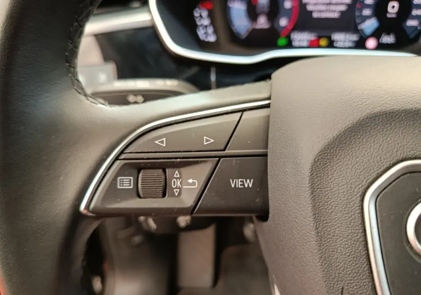 Gros plan sur le volant cuir noir multifonctions de l'Audi Q3 Sportback 35 TDI 2023 avec commandes intégrées.