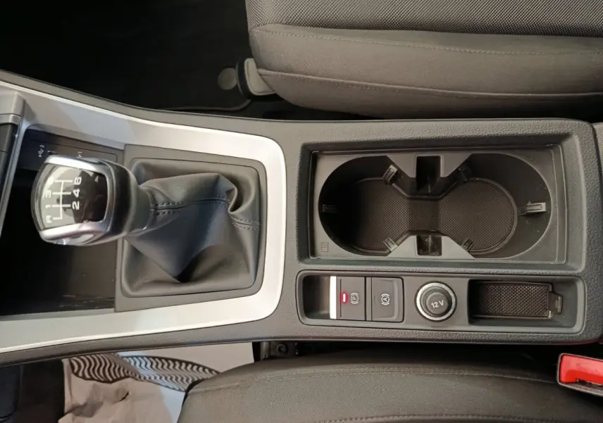 Gros plan sur la console centrale avec levier de vitesses manuel et porte-gobelets dans l'Audi Q3 Sportback noir.