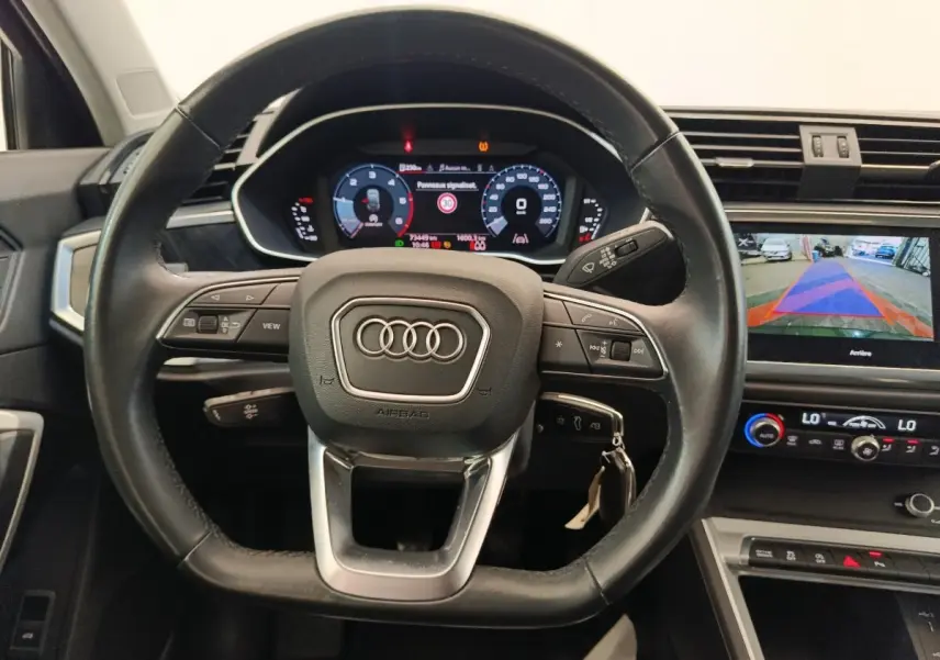 Vue intérieure centrée sur le volant cuir multifonctions d’un Audi Q3 Sportback 35 TDI 150 Business Line 2023.