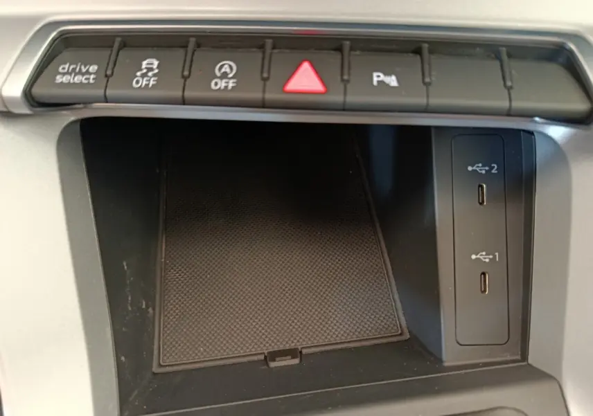 Vue rapprochée de la console centrale noire de l'Audi Q3 Sportback 35 TDI avec boutons de contrôle et ports USB.
