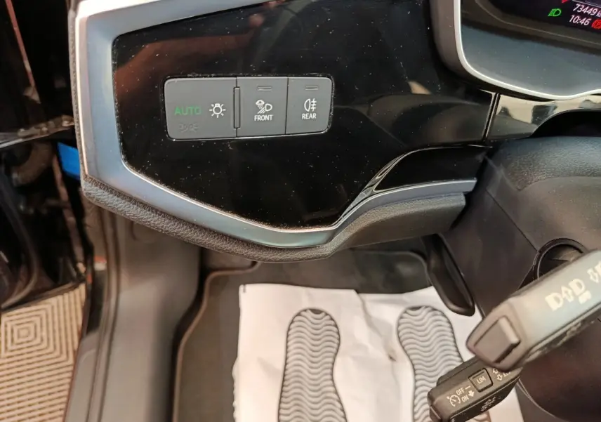 Détail du tableau de bord noir de l'Audi Q3 Sportback 35 TDI 150 Business Line, avec commandes d'éclairage et volant partiel.