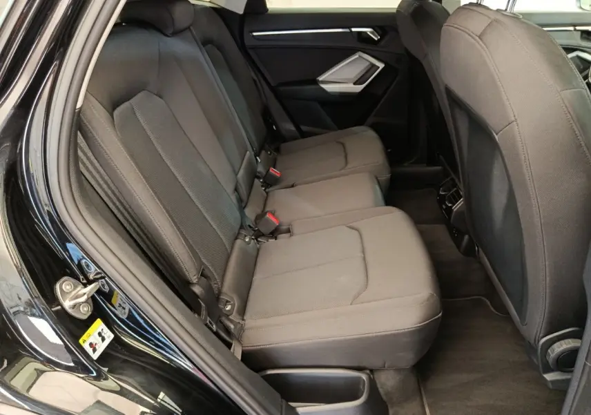 Vue intérieure côté gauche des sièges arrière noirs de l'Audi Q3 Sportback 35 TDI 150 Business Line 2023.