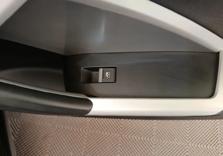 Bouton de commande de lève-vitre électrique sur la porte intérieure côté gauche d’un Audi Q3 Sportback noir.