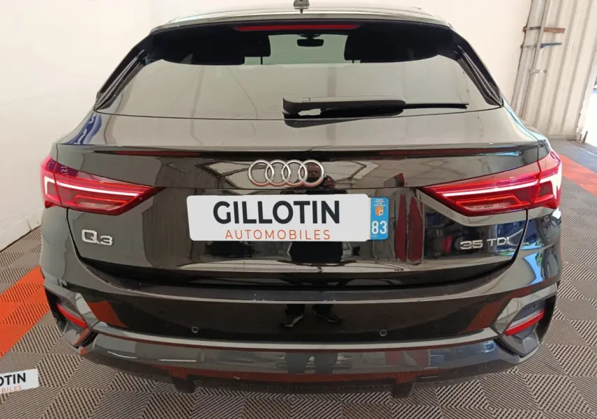 Vue arrière d'un Audi Q3 Sportback noir 35 TDI avec feux LED et logo Audi bien visibles.