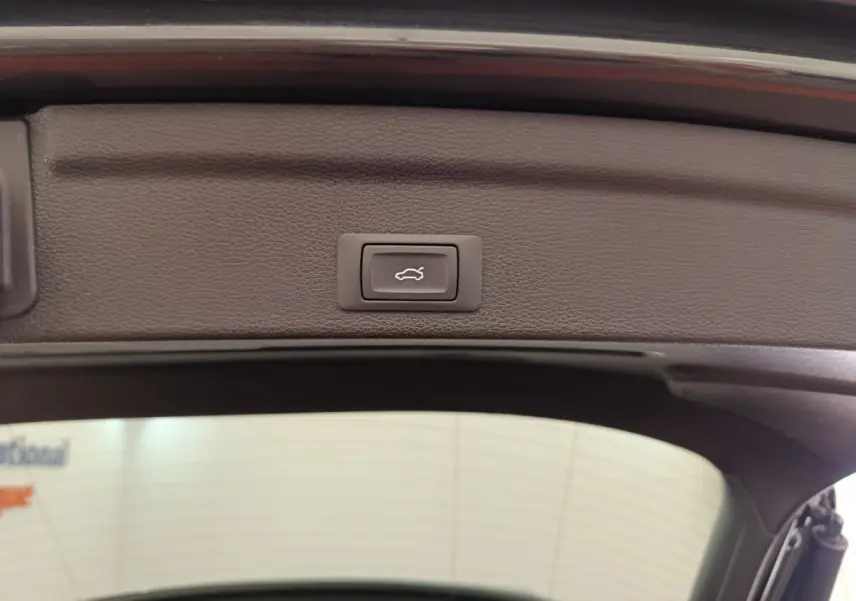 Bouton d'ouverture électrique du coffre sur la partie intérieure du hayon d'un Audi Q3 Sportback noir 2023.