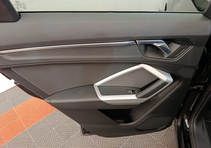 Vue rapprochée de la porte intérieure côté gauche noire de l'Audi Q3 Sportback 35 TDI 150 Business Line 2023.